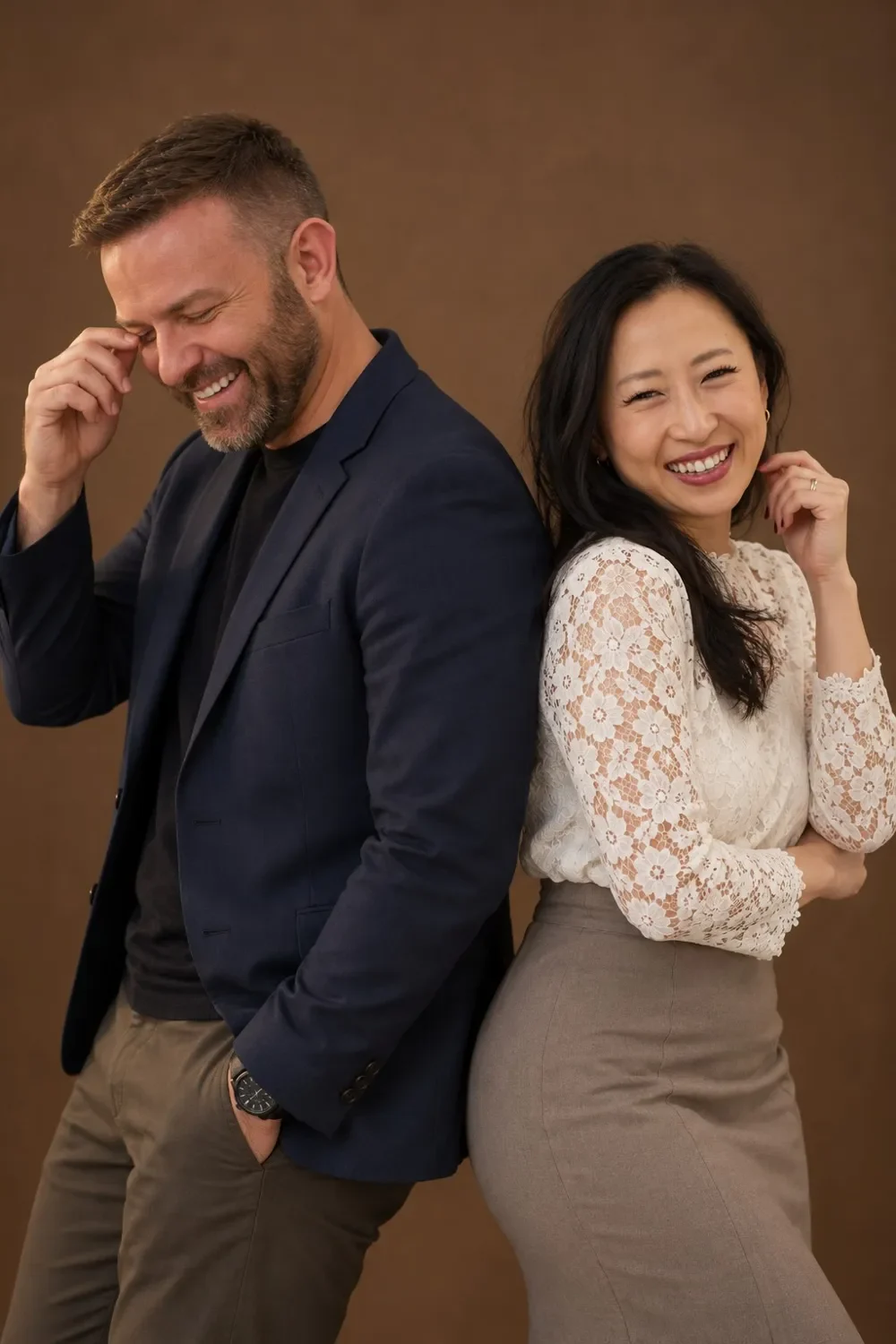 John Murray and Sabrina Runbeck standing back to back, laughing together
